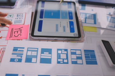 Mobil uygulama arayüzü kablo dizaynı hakkında modern ofisteki müşteri breif ve renk kodu ile fikir alışverişinde bulunan uu geliştirici ve ui tasarımcısını kapat. Yaratıcı dijital geliştirme ajansı.