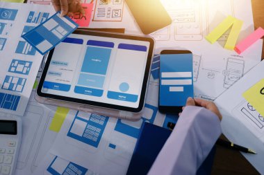 Mobil uygulama arayüzü kablo dizaynı hakkında modern ofisteki müşteri breif ve renk kodu ile fikir alışverişinde bulunan uu geliştirici ve ui tasarımcısını kapat. Yaratıcı dijital geliştirme ajansı.