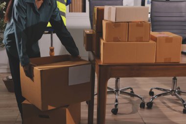 Girişim KOBİ küçük işletme girişimcisi önlük giyen Asyalı kadın dizüstü bilgisayar ve kutu kullanarak çevrimiçi müşterilere, çevrimiçi sme iş fikirlerine satış hazırlamak için siparişleri alır ve gözden geçirir.