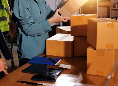 Girişim KOBİ küçük işletme girişimcisi önlük giyen Asyalı kadın dizüstü bilgisayar ve kutu kullanarak çevrimiçi müşterilere, çevrimiçi sme iş fikirlerine satış hazırlamak için siparişleri alır ve gözden geçirir.