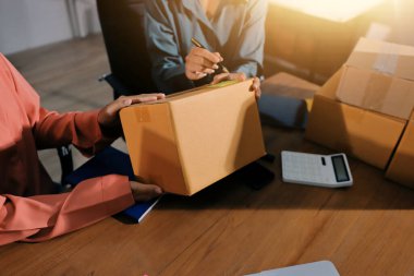 Girişim KOBİ küçük işletme girişimcisi önlük giyen Asyalı kadın dizüstü bilgisayar ve kutu kullanarak çevrimiçi müşterilere, çevrimiçi sme iş fikirlerine satış hazırlamak için siparişleri alır ve gözden geçirir.