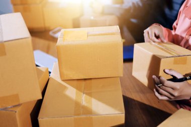 Girişim KOBİ küçük işletme girişimcisi önlük giyen Asyalı kadın dizüstü bilgisayar ve kutu kullanarak çevrimiçi müşterilere, çevrimiçi sme iş fikirlerine satış hazırlamak için siparişleri alır ve gözden geçirir.