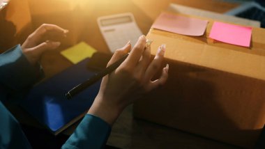 Girişim KOBİ küçük işletme girişimcisi önlük giyen Asyalı kadın dizüstü bilgisayar ve kutu kullanarak çevrimiçi müşterilere, çevrimiçi sme iş fikirlerine satış hazırlamak için siparişleri alır ve gözden geçirir.