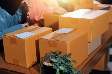 Girişim KOBİ küçük işletme girişimcisi önlük giyen Asyalı kadın dizüstü bilgisayar ve kutu kullanarak çevrimiçi müşterilere, çevrimiçi sme iş fikirlerine satış hazırlamak için siparişleri alır ve gözden geçirir.