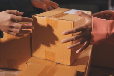 Girişim KOBİ küçük işletme girişimcisi önlük giyen Asyalı kadın dizüstü bilgisayar ve kutu kullanarak çevrimiçi müşterilere, çevrimiçi sme iş fikirlerine satış hazırlamak için siparişleri alır ve gözden geçirir.