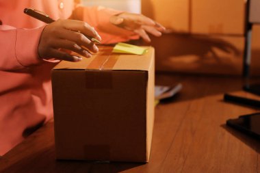 Girişim KOBİ küçük işletme girişimcisi önlük giyen Asyalı kadın dizüstü bilgisayar ve kutu kullanarak çevrimiçi müşterilere, çevrimiçi sme iş fikirlerine satış hazırlamak için siparişleri alır ve gözden geçirir.