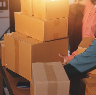 Girişim KOBİ küçük işletme girişimcisi önlük giyen Asyalı kadın dizüstü bilgisayar ve kutu kullanarak çevrimiçi müşterilere, çevrimiçi sme iş fikirlerine satış hazırlamak için siparişleri alır ve gözden geçirir.