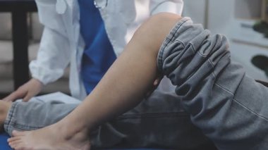 Bir hastanın ayak ve ayak bileğini muayene eden ve tedavi eden bir fizyoterapist ya da ayak hastalıkları uzmanı..