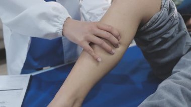 Bir hastanın ayak ve ayak bileğini muayene eden ve tedavi eden bir fizyoterapist ya da ayak hastalıkları uzmanı..