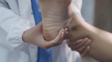 Bir hastanın ayak ve ayak bileğini muayene eden ve tedavi eden bir fizyoterapist ya da ayak hastalıkları uzmanı..