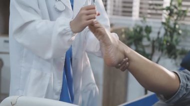 Bir hastanın ayak ve ayak bileğini muayene eden ve tedavi eden bir fizyoterapist ya da ayak hastalıkları uzmanı..