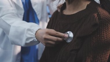 Yaşlı hastaların hayati organlarını incelemek için steteskop kullanan sevimli genç Latin doktor. Çekici İspanyol doktor, beyaz yaşlı bir kadının kalbini ve ciğerlerini kontrol etmek için tıbbi bir alet kullanıyor.