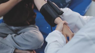 Teste gir, elinden geleni yap. Evde tansiyon ölçer ile yaşlı bir kadını muayene eden bir doktorun fotoğrafı..