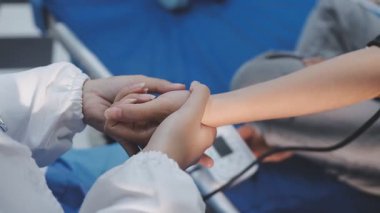 Şefkatli Doktor Dostça Tıbbi Çevrede Hastanın Elini Tutarak Rahatlatıcı Destek Teklif Ediyor