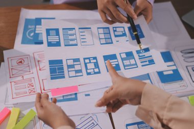 Mobil uygulama arayüzü kablo dizaynı hakkında modern ofisteki müşteri breif ve renk kodu ile fikir alışverişinde bulunan uu geliştirici ve ui tasarımcısını kapat. Yaratıcı dijital geliştirme ajansı.