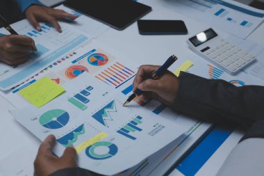 Ofiste çalışan denetçi ve muhasebeci ekibi mali verileri ve muhasebe kayıtlarını hesap makinesiyle analiz ediyor. Muhasebe şirketi kârlı nakit akışı için finansman ve vergilendirme planlaması sağlıyor.