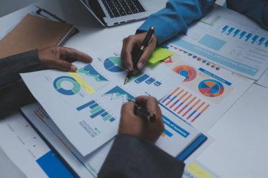 Ofiste çalışan denetçi ve muhasebeci ekibi mali verileri ve muhasebe kayıtlarını hesap makinesiyle analiz ediyor. Muhasebe şirketi kârlı nakit akışı için finansman ve vergilendirme planlaması sağlıyor.