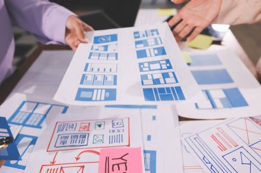 Mobil uygulama arayüzü kablo dizaynı hakkında modern ofisteki müşteri breif ve renk kodu ile fikir alışverişinde bulunan uu geliştirici ve ui tasarımcısını kapat. Yaratıcı dijital geliştirme ajansı.