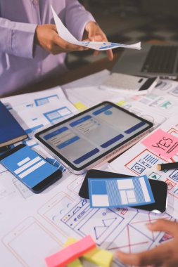 Mobil uygulama arayüzü kablo dizaynı hakkında modern ofisteki müşteri breif ve renk kodu ile fikir alışverişinde bulunan uu geliştirici ve ui tasarımcısını kapat. Yaratıcı dijital geliştirme ajansı.