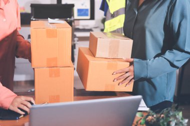 Girişim KOBİ küçük işletme girişimcisi önlük giyen Asyalı kadın dizüstü bilgisayar ve kutu kullanarak çevrimiçi müşterilere, çevrimiçi sme iş fikirlerine satış hazırlamak için siparişleri alır ve gözden geçirir.