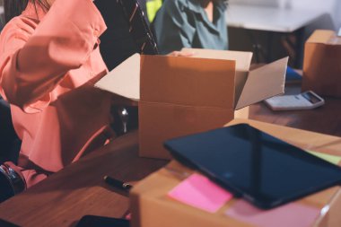 Girişim KOBİ küçük işletme girişimcisi önlük giyen Asyalı kadın dizüstü bilgisayar ve kutu kullanarak çevrimiçi müşterilere, çevrimiçi sme iş fikirlerine satış hazırlamak için siparişleri alır ve gözden geçirir.