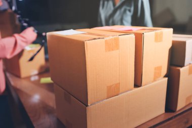 Girişim KOBİ küçük işletme girişimcisi önlük giyen Asyalı kadın dizüstü bilgisayar ve kutu kullanarak çevrimiçi müşterilere, çevrimiçi sme iş fikirlerine satış hazırlamak için siparişleri alır ve gözden geçirir.