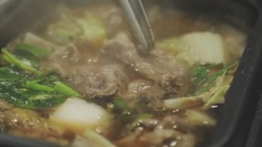 Masaüstü Shabu set konsepti. Bir tencere lezzetli sebze ve et yahnisi..