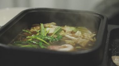 Masaüstü Shabu set konsepti. Bir tencere lezzetli sebze ve et yahnisi..