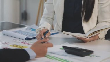 İki İşadamı İşyerinde Hesap Makinesini kullanarak Faturaları Hesaplıyor. İş ekibi toplantısı ve proje planı. İş adamları toplantı odasında tartışıyor.