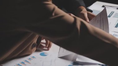 İki İşadamı İşyerinde Hesap Makinesini kullanarak Faturaları Hesaplıyor. İş ekibi toplantısı ve proje planı. İş adamları toplantı odasında tartışıyor.