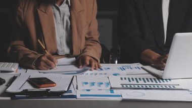 İki İşadamı İşyerinde Hesap Makinesini kullanarak Faturaları Hesaplıyor. İş ekibi toplantısı ve proje planı. İş adamları toplantı odasında tartışıyor.