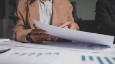 İki İşadamı İşyerinde Hesap Makinesini kullanarak Faturaları Hesaplıyor. İş ekibi toplantısı ve proje planı. İş adamları toplantı odasında tartışıyor.