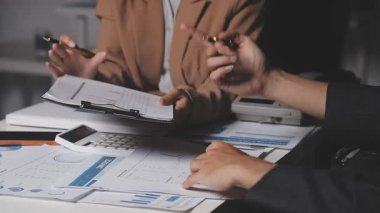 İki İşadamı İşyerinde Hesap Makinesini kullanarak Faturaları Hesaplıyor. İş ekibi toplantısı ve proje planı. İş adamları toplantı odasında tartışıyor.