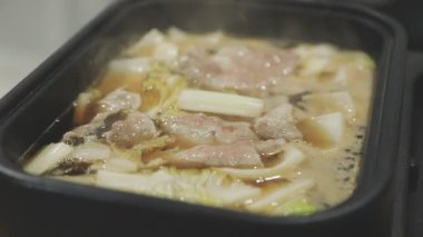 Tayland usulü ızgara tavasına yakın plan, Moo Kratha olarak bilinir, domuz eti, karides ve sebzeli ızgara ve çorba. Tayland 'da popüler Asya yemek deneyimi.