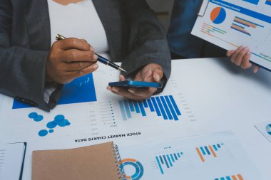 Ofiste çalışan denetçi ve muhasebeci ekibi mali verileri ve muhasebe kayıtlarını hesap makinesiyle analiz ediyor. Muhasebe şirketi kârlı nakit akışı için finansman ve vergilendirme planlaması sağlıyor.