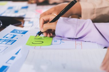 Mobil uygulama arayüzü kablo dizaynı hakkında modern ofisteki müşteri breif ve renk kodu ile fikir alışverişinde bulunan uu geliştirici ve ui tasarımcısını kapat. Yaratıcı dijital geliştirme ajansı.