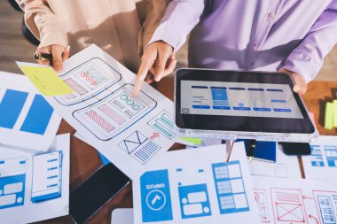 Mobil uygulama arayüzü kablo dizaynı hakkında modern ofisteki müşteri breif ve renk kodu ile fikir alışverişinde bulunan uu geliştirici ve ui tasarımcısını kapat. Yaratıcı dijital geliştirme ajansı.