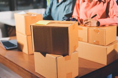 Girişim KOBİ küçük işletme girişimcisi önlük giyen Asyalı kadın dizüstü bilgisayar ve kutu kullanarak çevrimiçi müşterilere, çevrimiçi sme iş fikirlerine satış hazırlamak için siparişleri alır ve gözden geçirir.