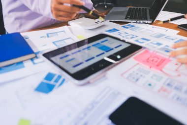 Mobil uygulama arayüzü kablo dizaynı hakkında modern ofisteki müşteri breif ve renk kodu ile fikir alışverişinde bulunan uu geliştirici ve ui tasarımcısını kapat. Yaratıcı dijital geliştirme ajansı.