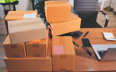 Girişim KOBİ küçük işletme girişimcisi önlük giyen Asyalı kadın dizüstü bilgisayar ve kutu kullanarak çevrimiçi müşterilere, çevrimiçi sme iş fikirlerine satış hazırlamak için siparişleri alır ve gözden geçirir.