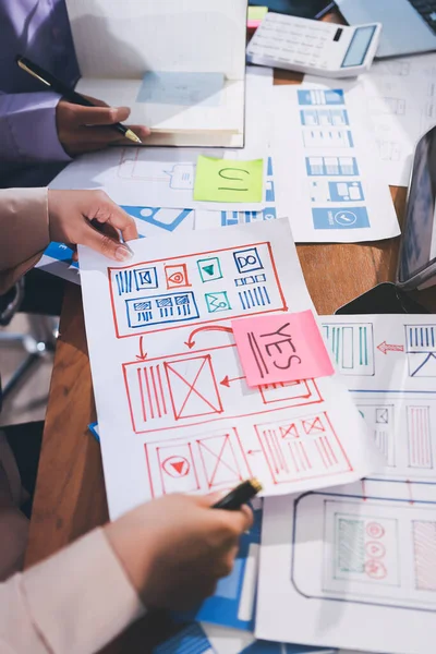 Mobil uygulama arayüzü kablo dizaynı hakkında modern ofisteki müşteri breif ve renk kodu ile fikir alışverişinde bulunan uu geliştirici ve ui tasarımcısını kapat. Yaratıcı dijital geliştirme ajansı.