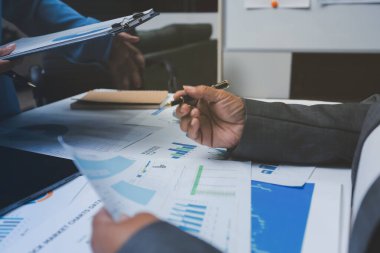 Ofiste çalışan denetçi ve muhasebeci ekibi mali verileri ve muhasebe kayıtlarını hesap makinesiyle analiz ediyor. Muhasebe şirketi kârlı nakit akışı için finansman ve vergilendirme planlaması sağlıyor.