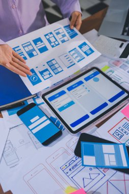 Mobil uygulama arayüzü kablo dizaynı hakkında modern ofisteki müşteri breif ve renk kodu ile fikir alışverişinde bulunan uu geliştirici ve ui tasarımcısını kapat. Yaratıcı dijital geliştirme ajansı.