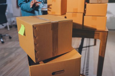 Girişim KOBİ küçük işletme girişimcisi önlük giyen Asyalı kadın dizüstü bilgisayar ve kutu kullanarak çevrimiçi müşterilere, çevrimiçi sme iş fikirlerine satış hazırlamak için siparişleri alır ve gözden geçirir.