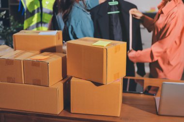 Girişim KOBİ küçük işletme girişimcisi önlük giyen Asyalı kadın dizüstü bilgisayar ve kutu kullanarak çevrimiçi müşterilere, çevrimiçi sme iş fikirlerine satış hazırlamak için siparişleri alır ve gözden geçirir.