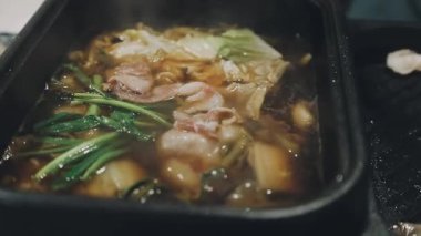 Shabu Shabu veya Sukiyaki veya güveç, domuz restoranında Japon yemekleri yemek çubukları, kullanarak tutan el