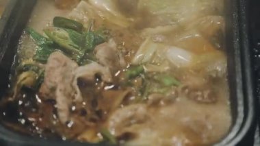 Shabu Shabu veya Sukiyaki veya güveç, domuz restoranında Japon yemekleri yemek çubukları, kullanarak tutan el