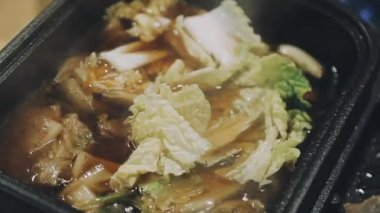 Shabu Shabu veya Sukiyaki veya güveç, domuz restoranında Japon yemekleri yemek çubukları, kullanarak tutan el