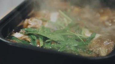 Shabu Shabu veya Sukiyaki veya güveç, domuz restoranında Japon yemekleri yemek çubukları, kullanarak tutan el