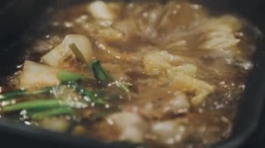 Shabu Shabu veya Sukiyaki veya güveç, domuz restoranında Japon yemekleri yemek çubukları, kullanarak tutan el